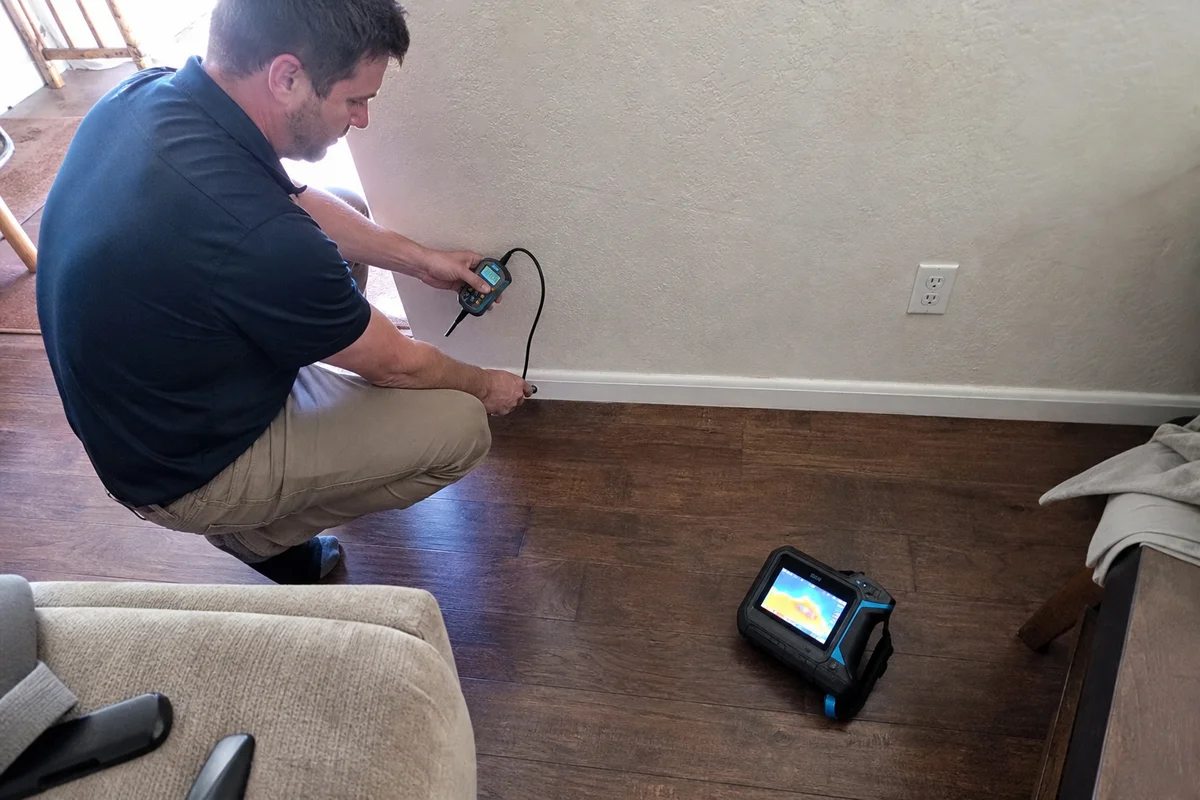 Technician documenting moisture readings on a wall