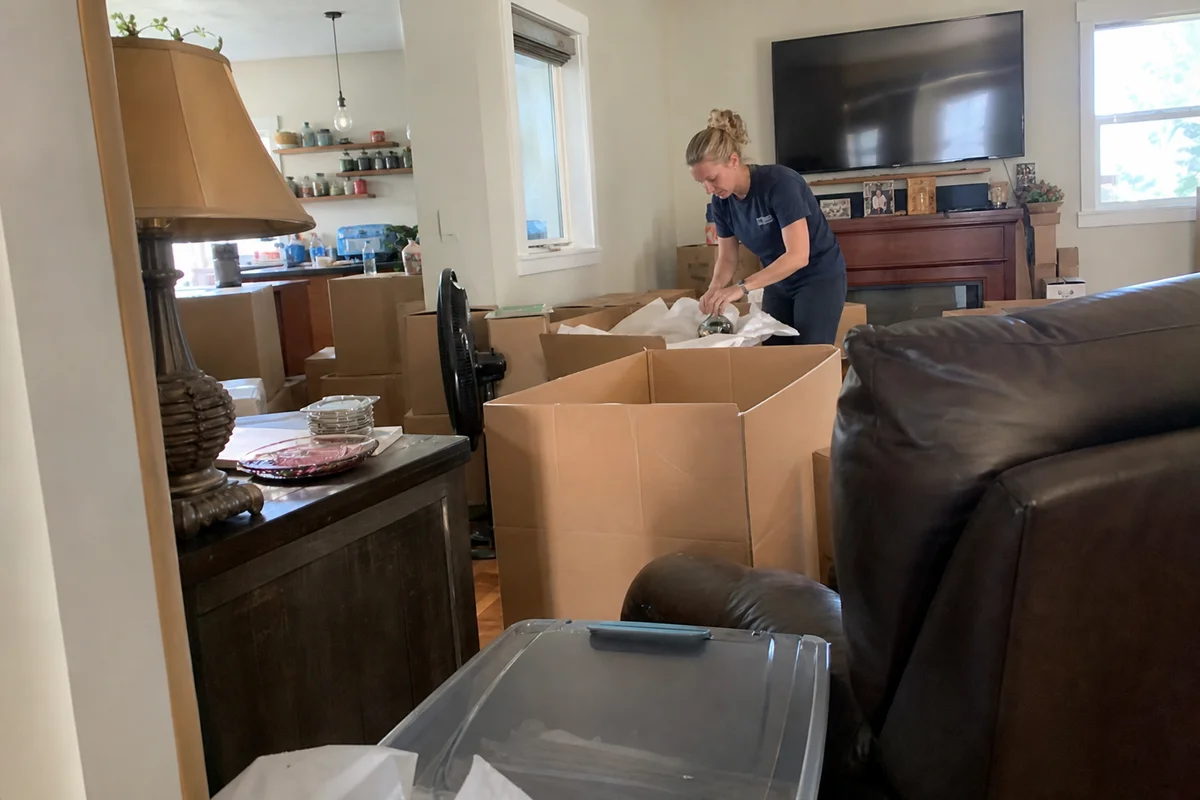 Crew boxing and labeling belongings for pack-out
