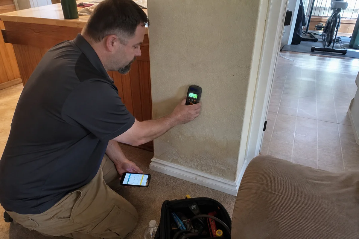 Technician using a moisture meter on drywall